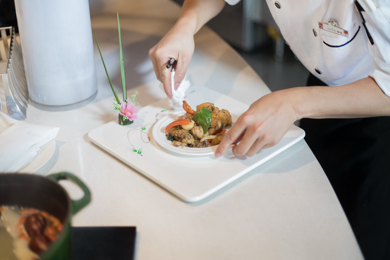 A cook preparing a plate
