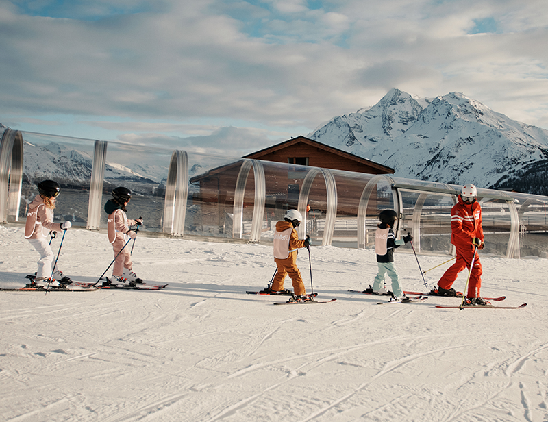 A ski instructor skiing with kids