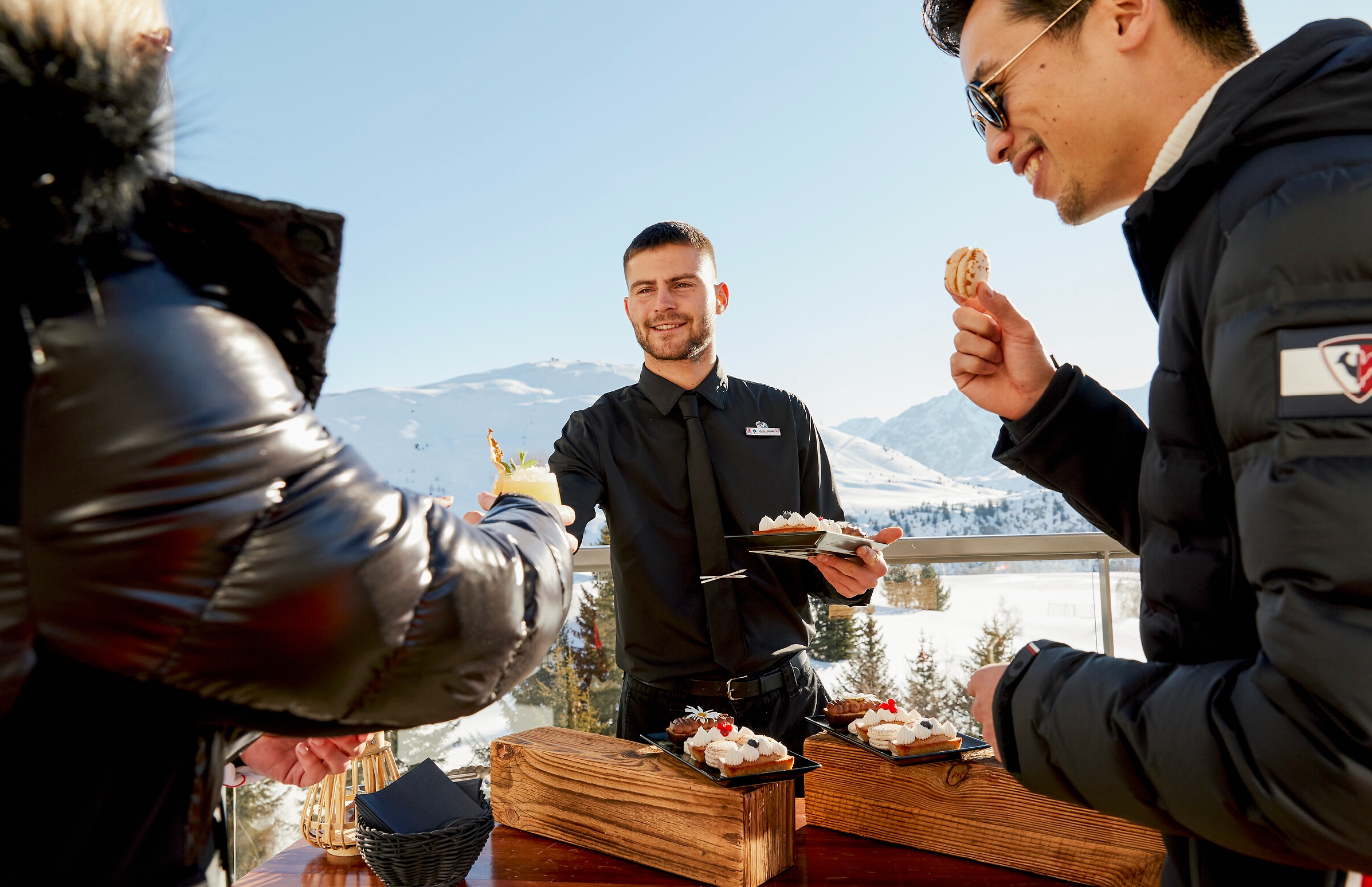 A waiter helping customer on a sunny terrace in one of our Resorts in the French Alps