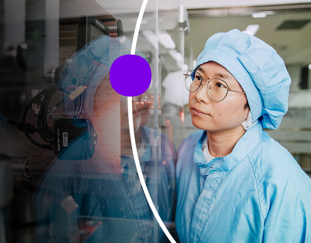 Person in full protective gear, using a lab instrument