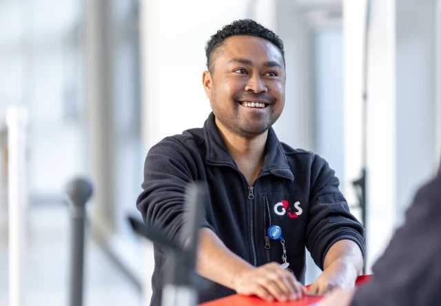 G4S employee smiling with ambulance in background