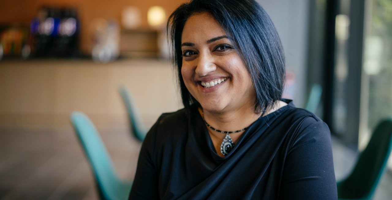 Smiling woman in an office cafeteria.