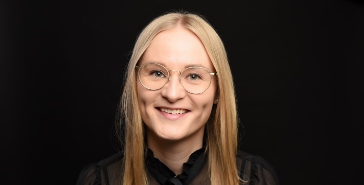 Friendly smiling woman in front of black background