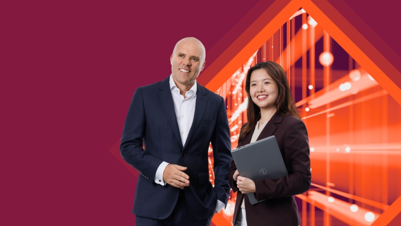 Two people of different age, ethnics and gender standing in front of a technical background.