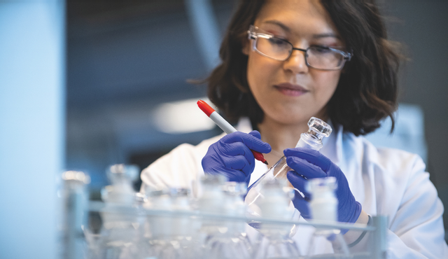 Scientist labeling vial in lab