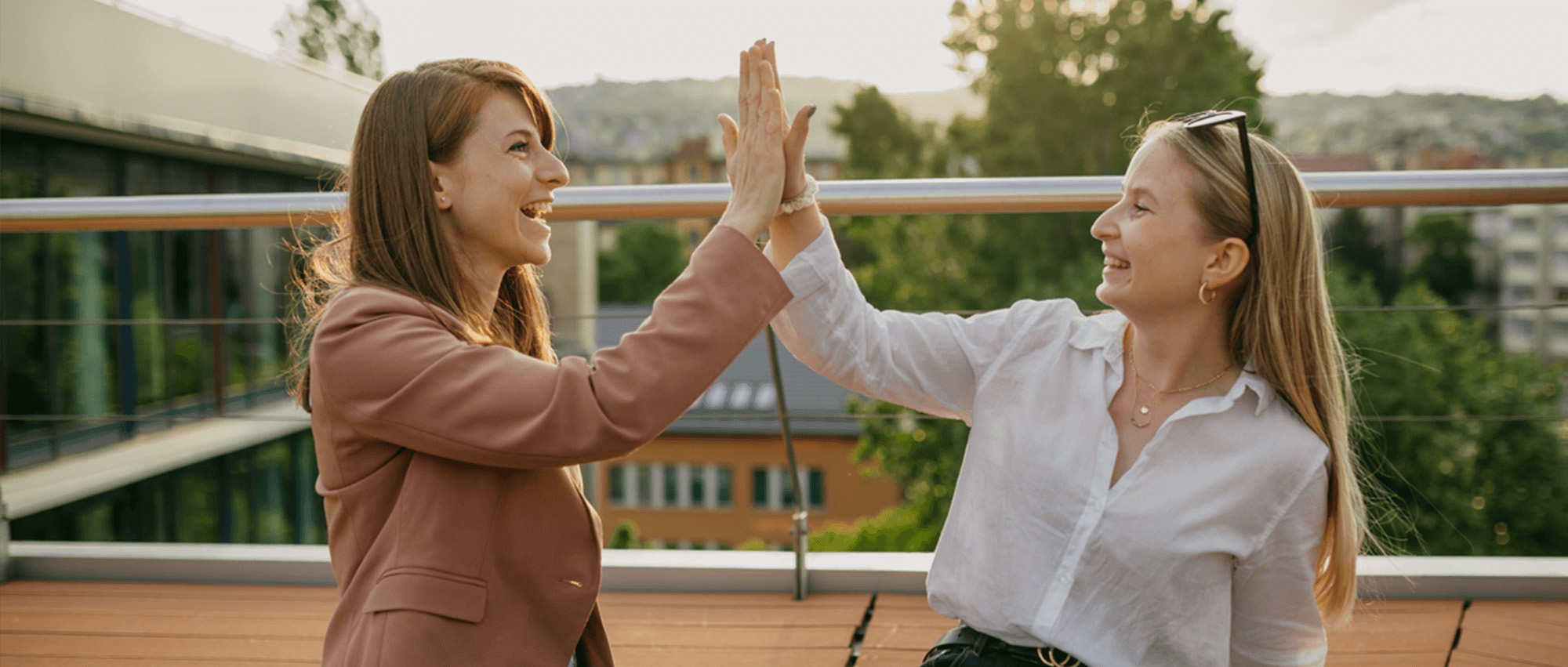 Two employees high-fiving in the terrace