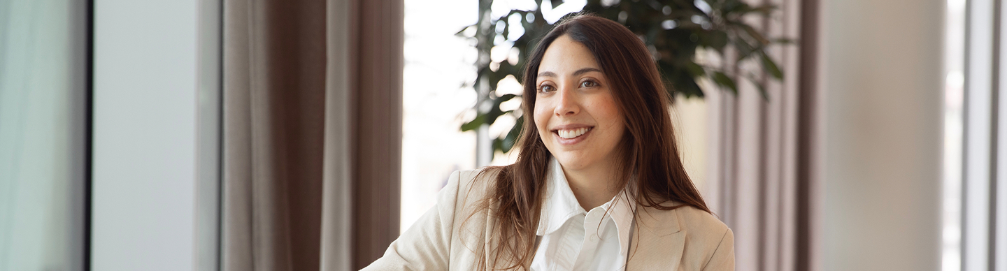 Smiling woman in blazer by window indoors