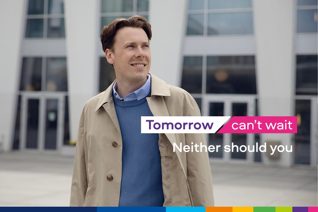 Person in coat outside building with slogan text