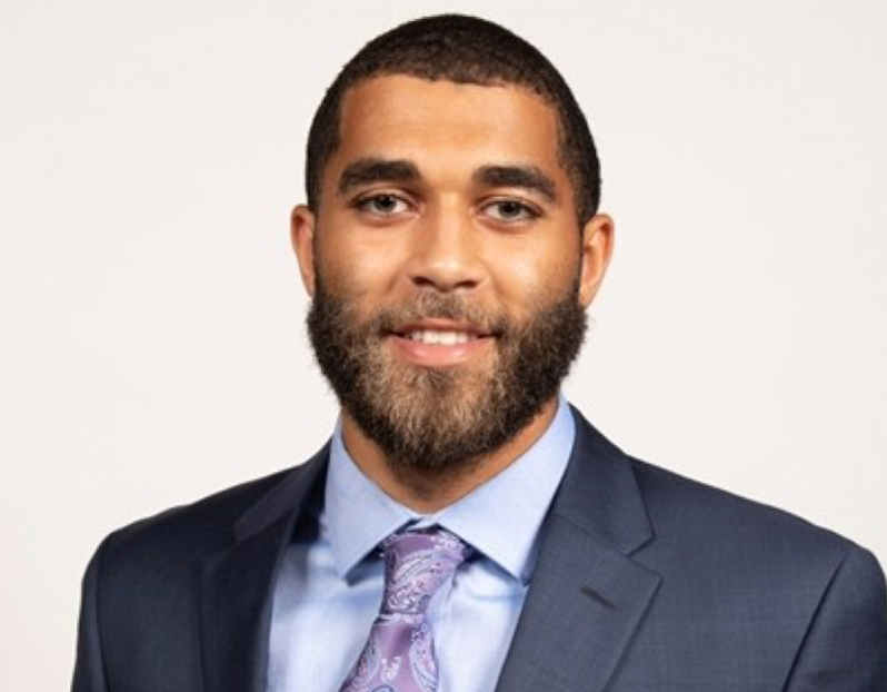 Person wearing a dark blue suit on a neutral background