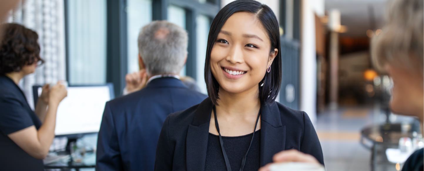 Woman smiling in a converstation with two members of staff