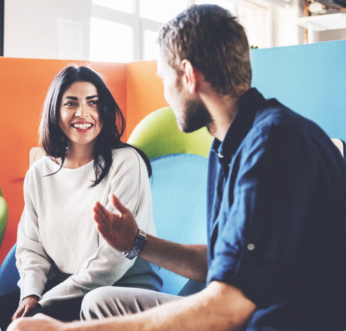 Woman and man talking while sitting on a couch