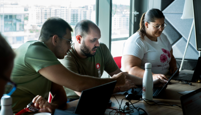 Colleagues working together on laptops at table