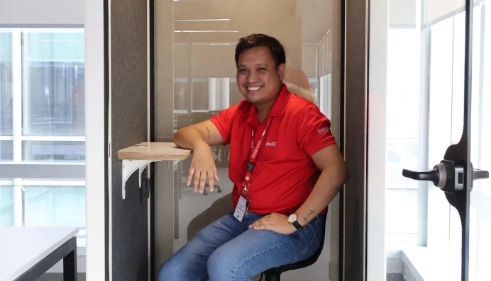 Man smiling while sitting in office booth