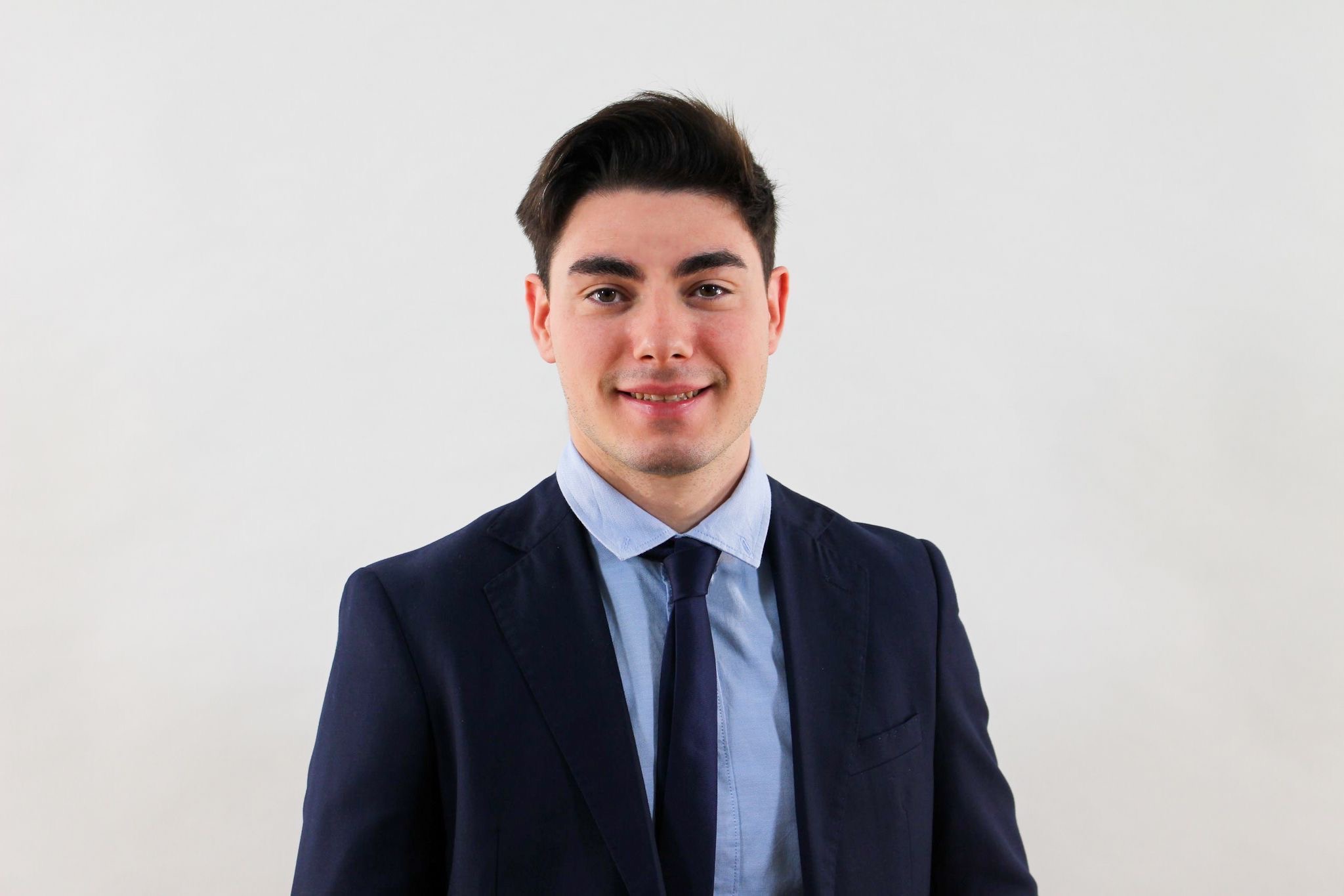 Young man smiling in suit and tie