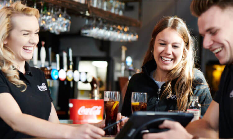 smiling staff in uniform working in a bar