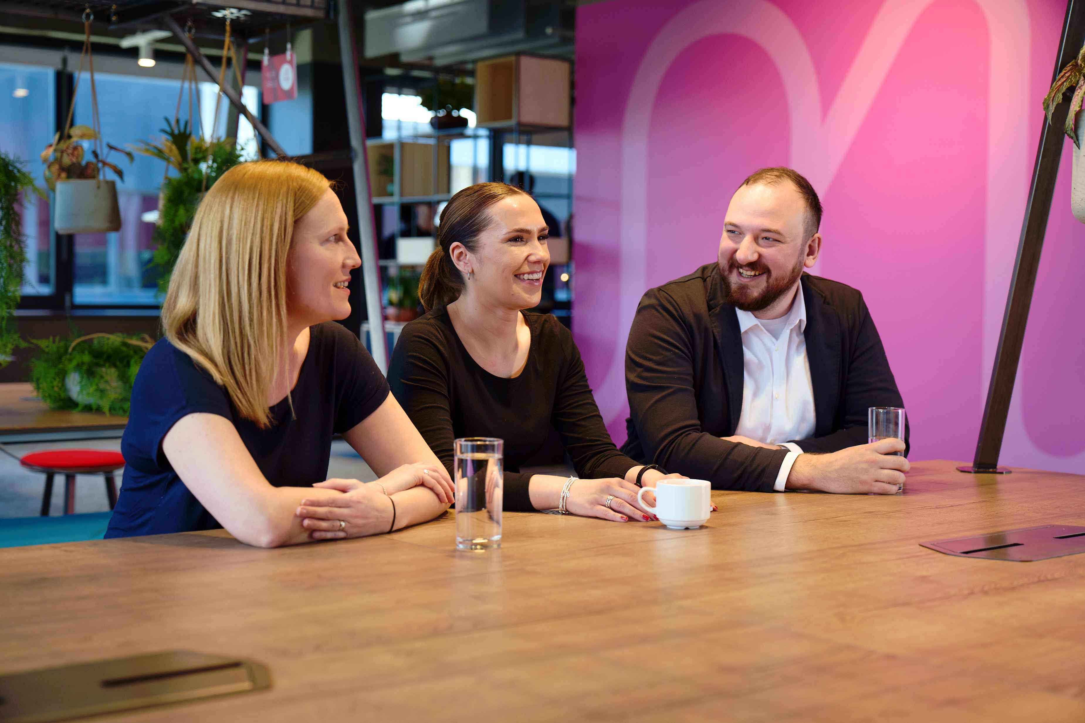 Three virgin money colleagues sitting at a table talking