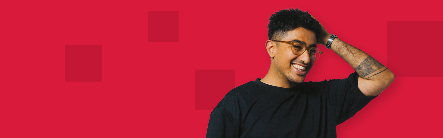 Man in black t-shirt holding his head against a red background with dark red pixels on it