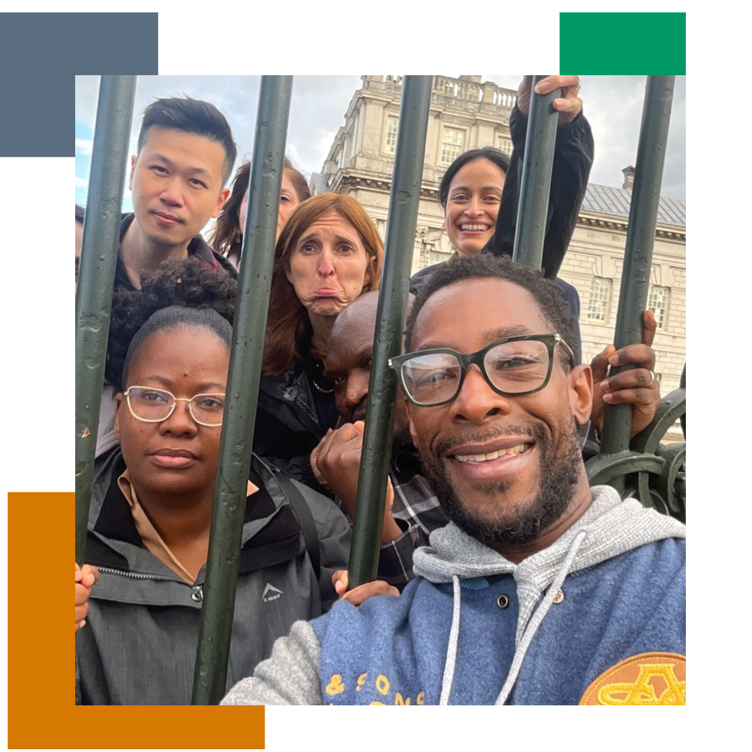 Group of people posing for a selfie behind iron bars