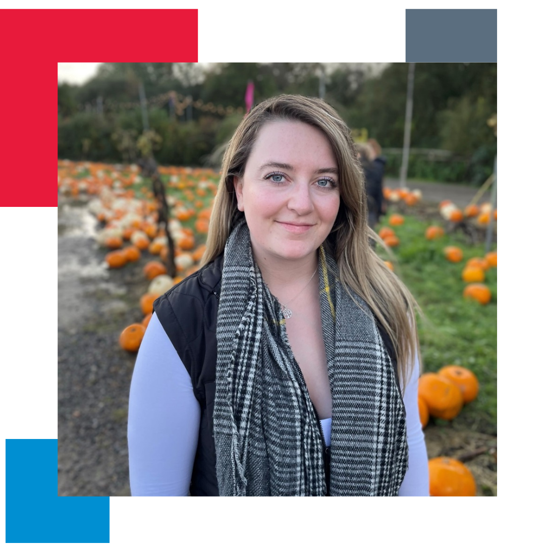 Woman in pumpkin field looking directly down the camera