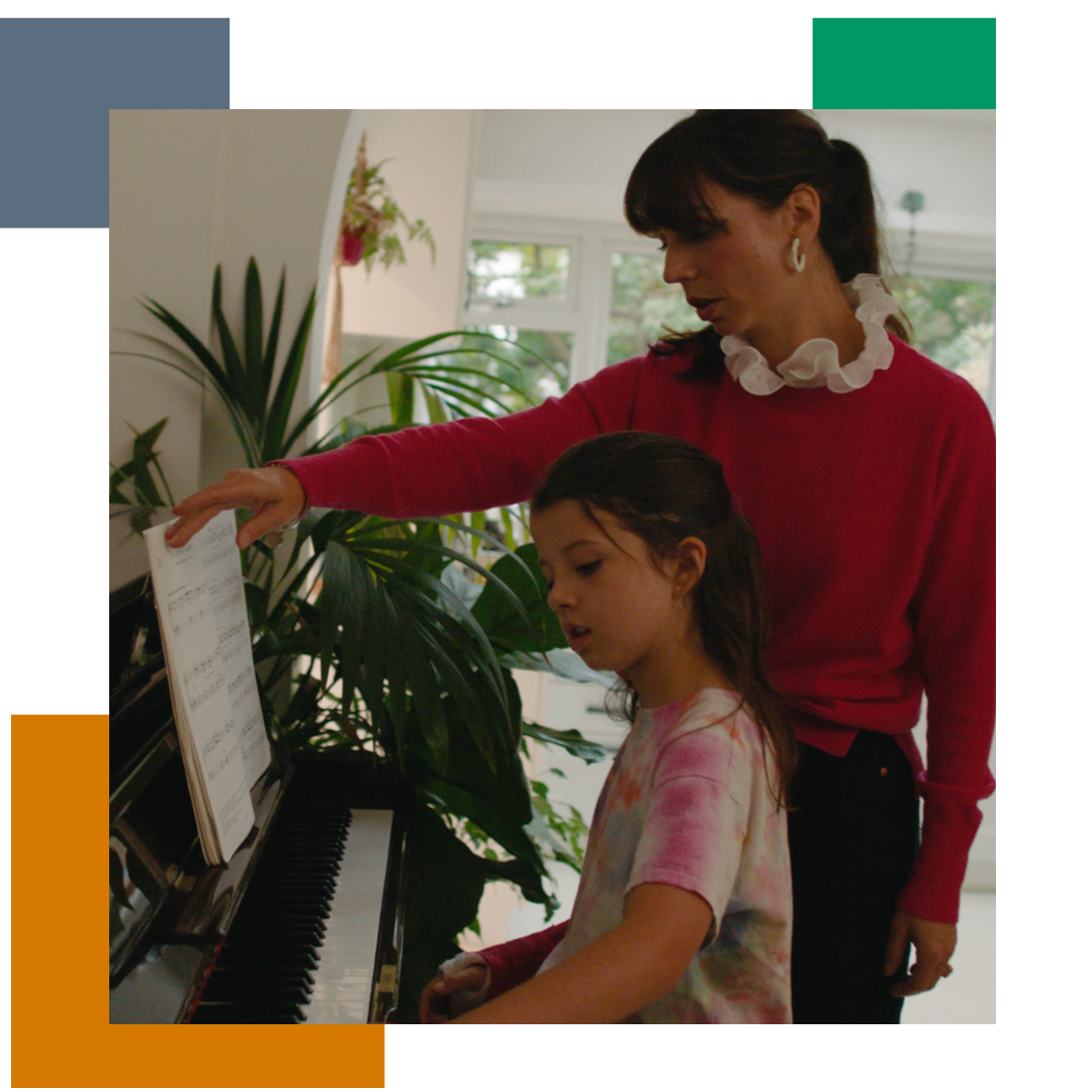 Woman and her daughter at home, playing the piano together