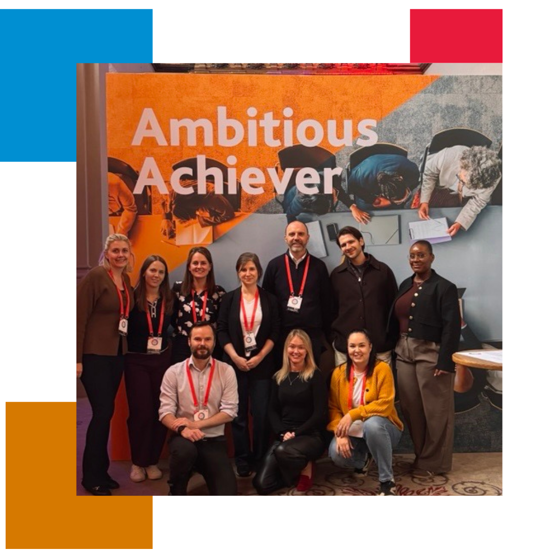 Group of people in front of a banner saying ambitious achiever on it