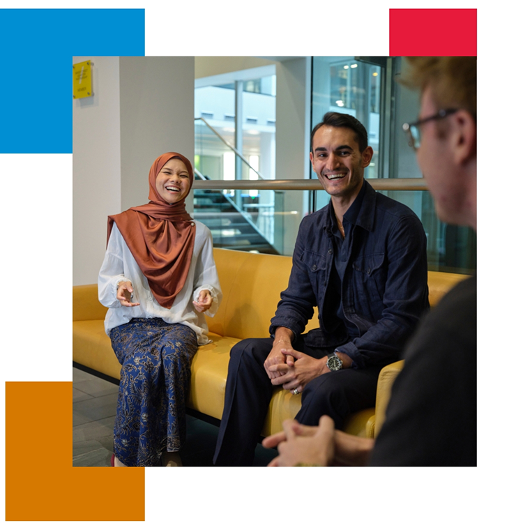 Three people talking in office lounge