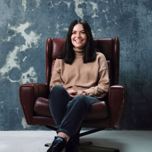 Person seated in chair against textured wall