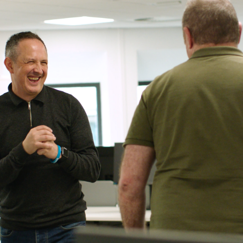 Two men sharing a laugh in an office together