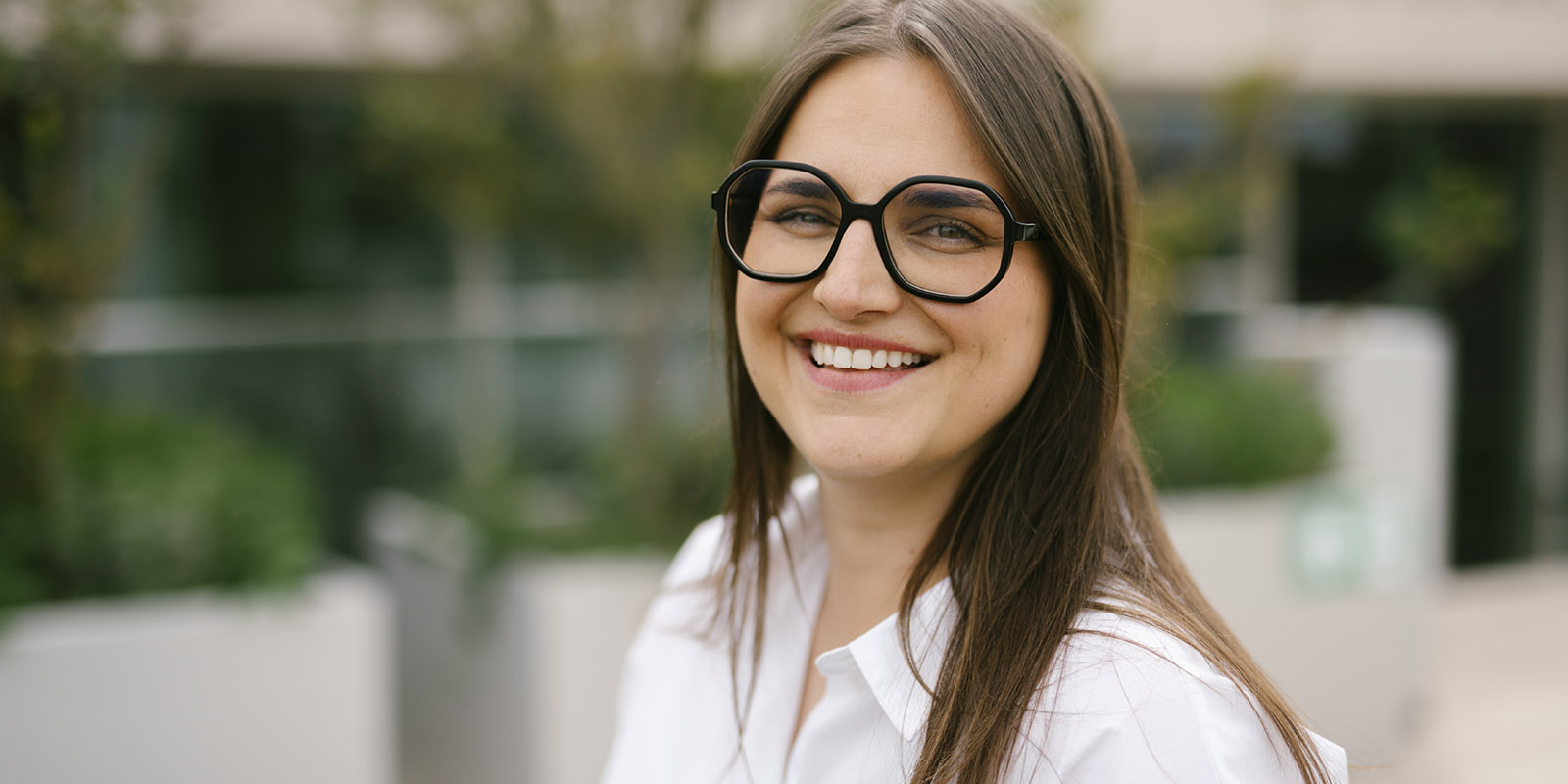 Melissa is wearing glasses and a white shirt