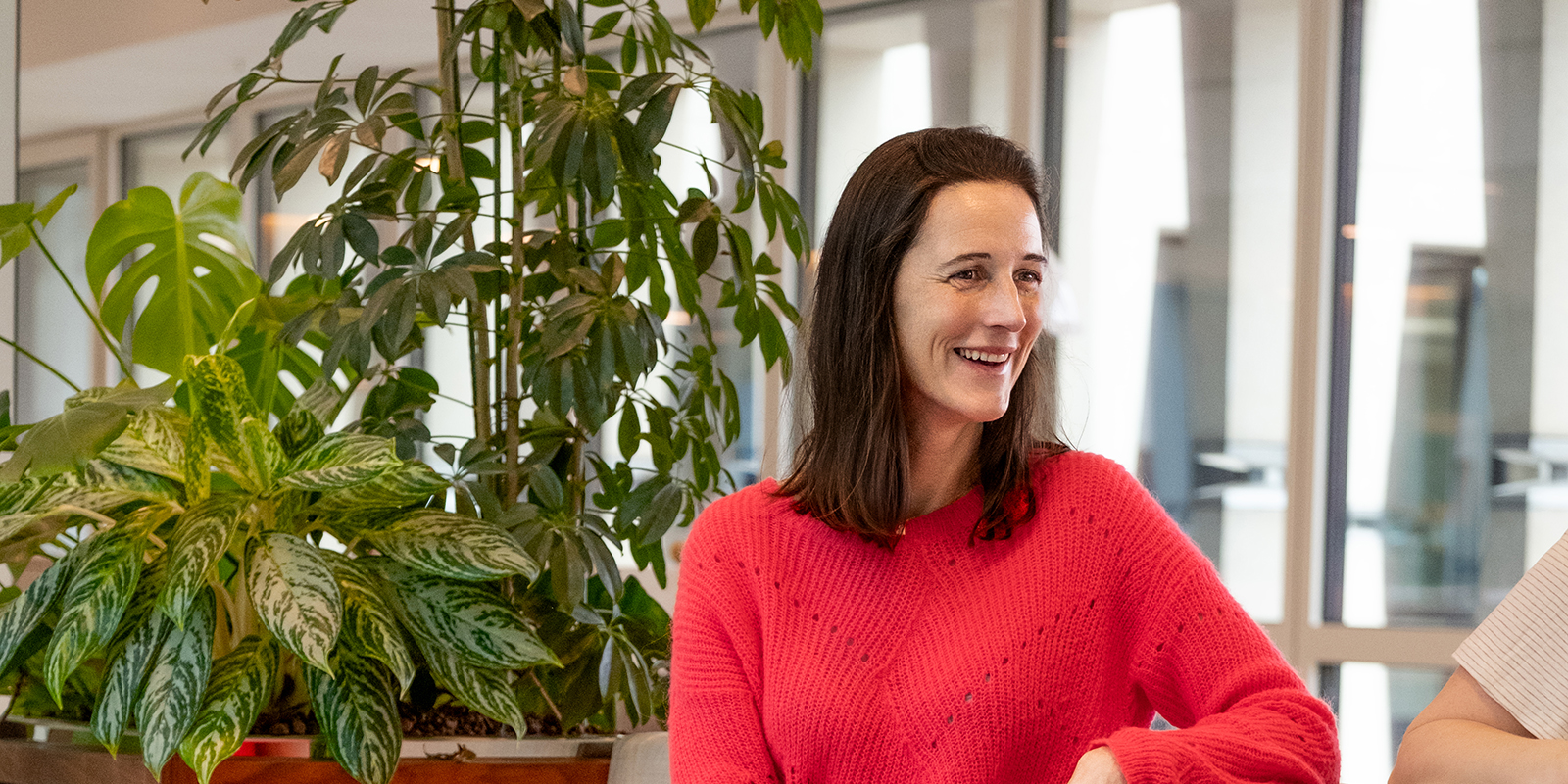 Inès, wearing a red jumper, is smiling