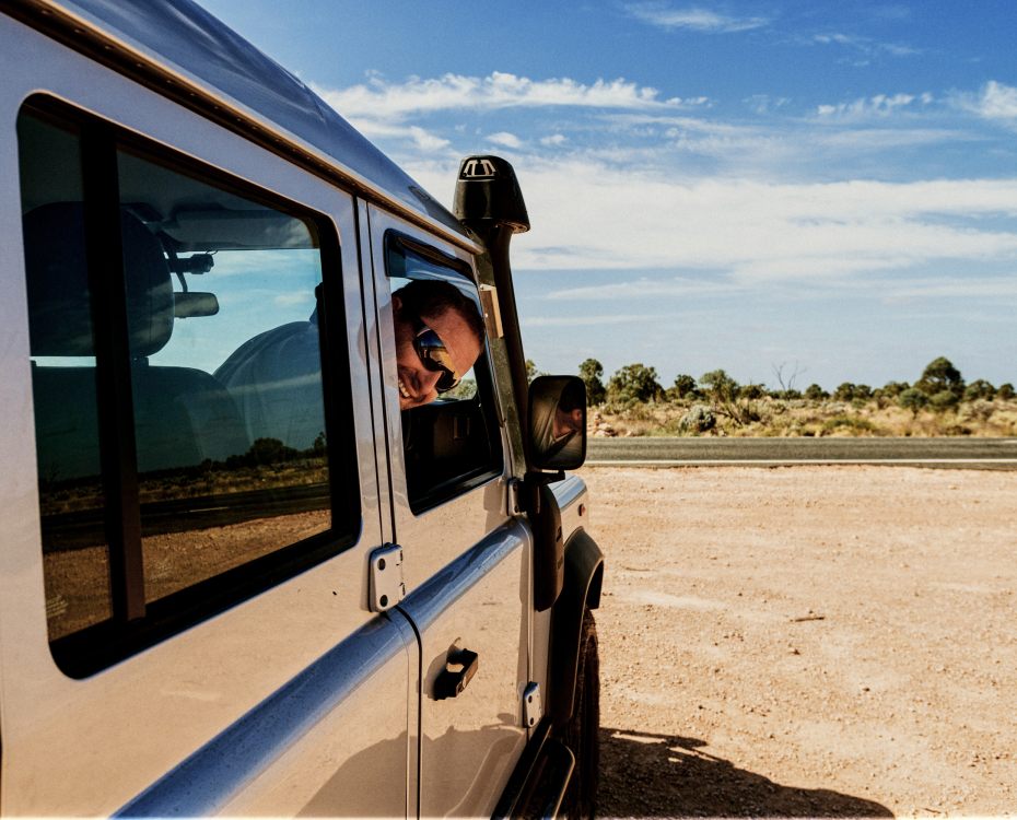 Man looking out the window of a van in the desert