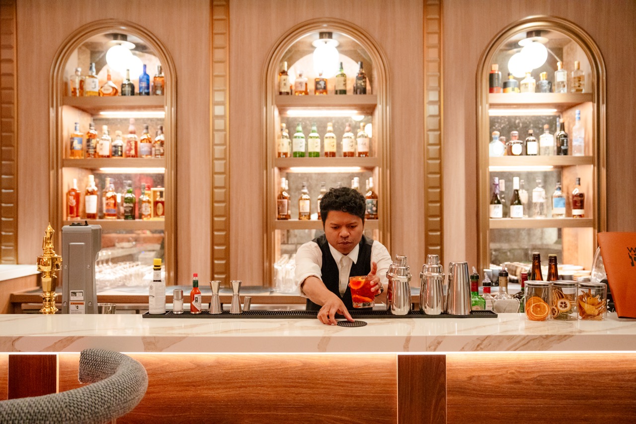 A barman serving a drink on the bar