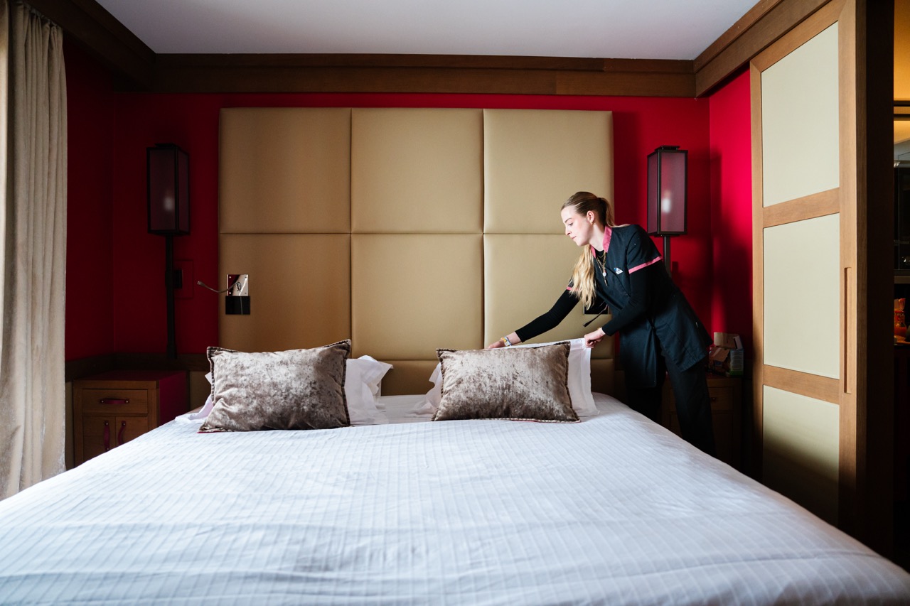 A housekeeper arranging a bed