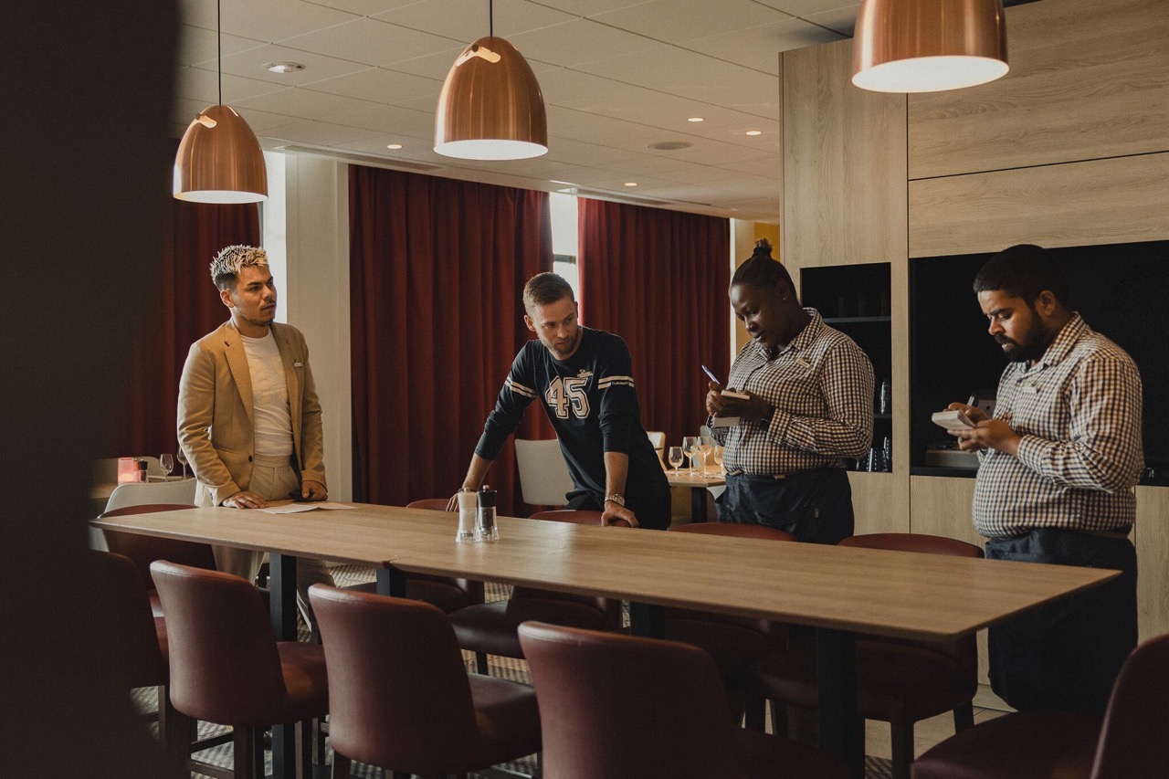 A team standing up, discussing and taking notes