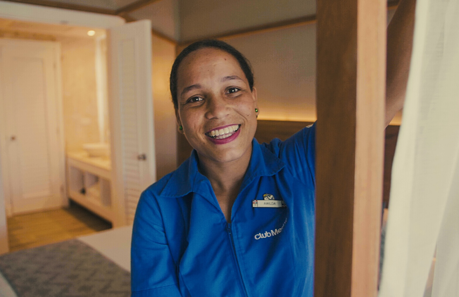 Une femme G.E souriant dans la chambre d'un Resort Club Med