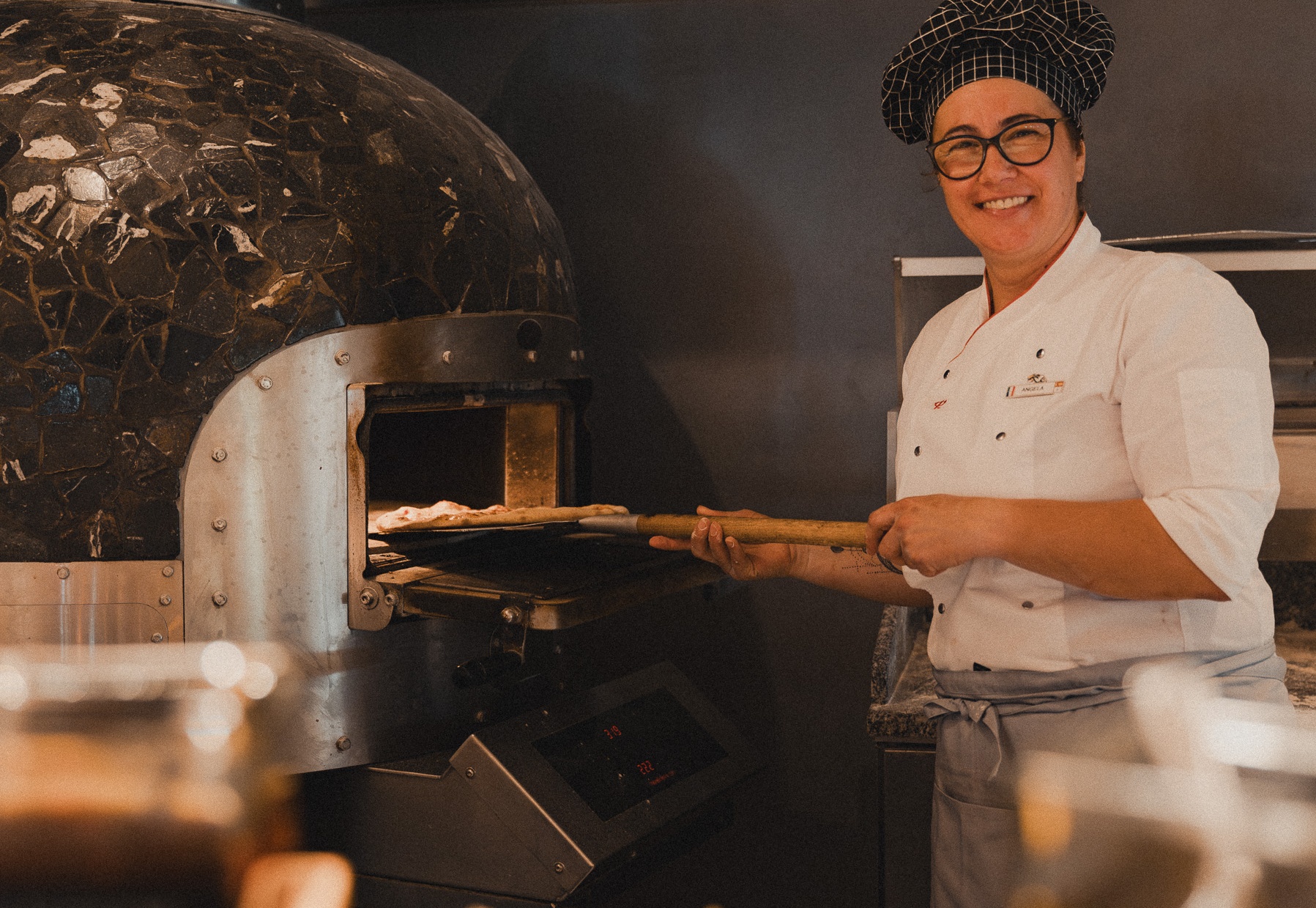 Cook preparing a pizza