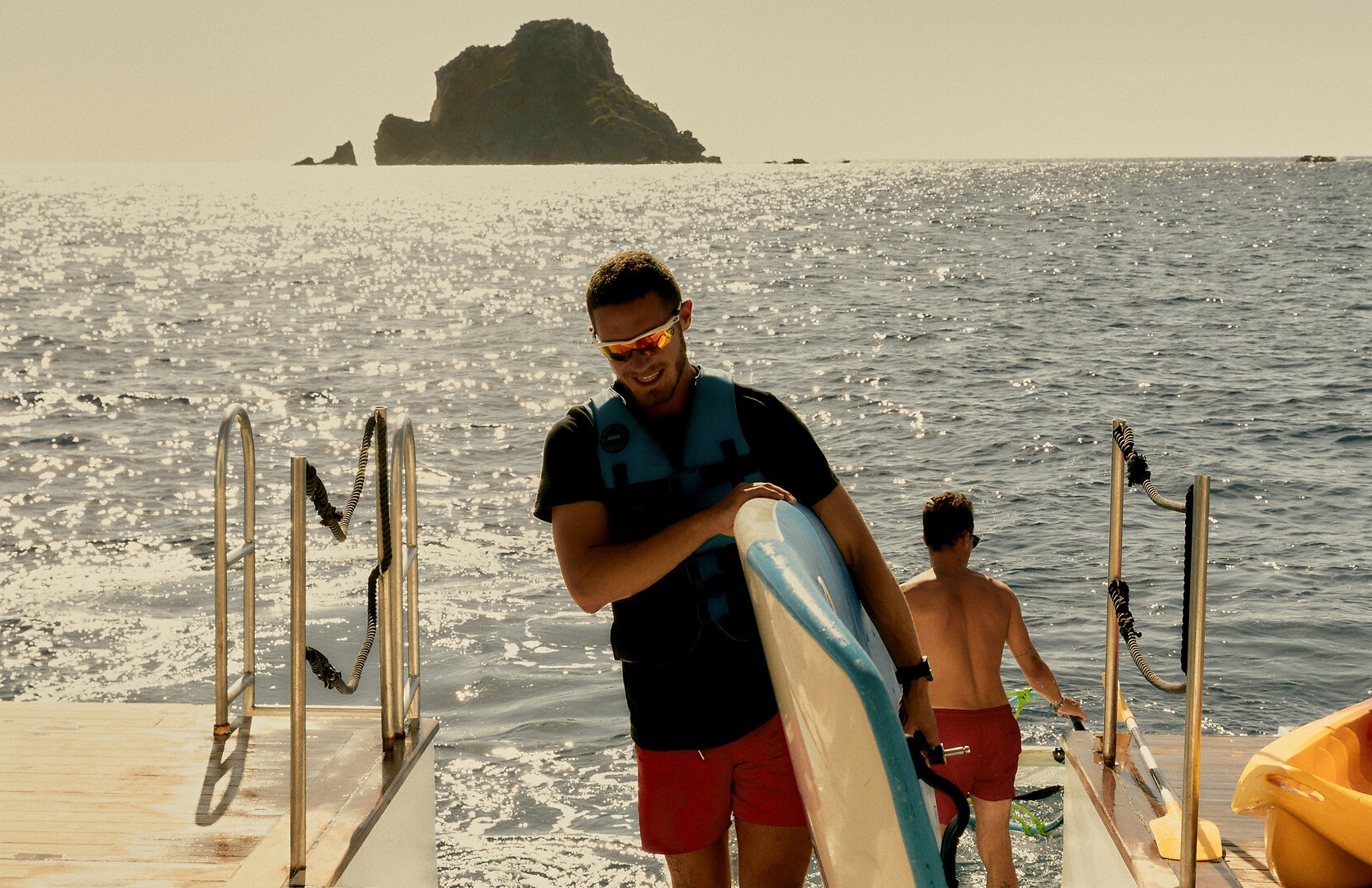 G.O Sports Nautiques en alternance au Club Med portant une planche à voile