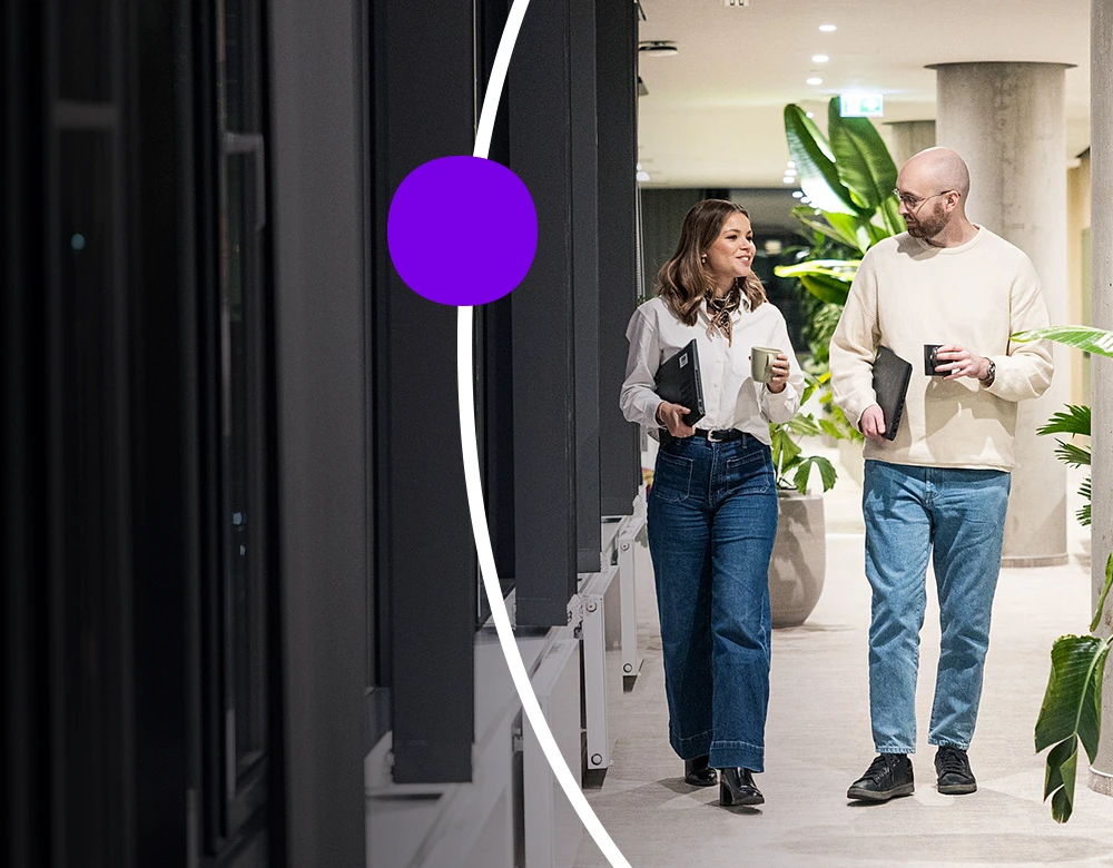 Two Sanofians walking through office