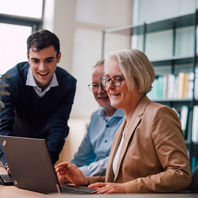 Sanofians gathering around laptop in meeting
