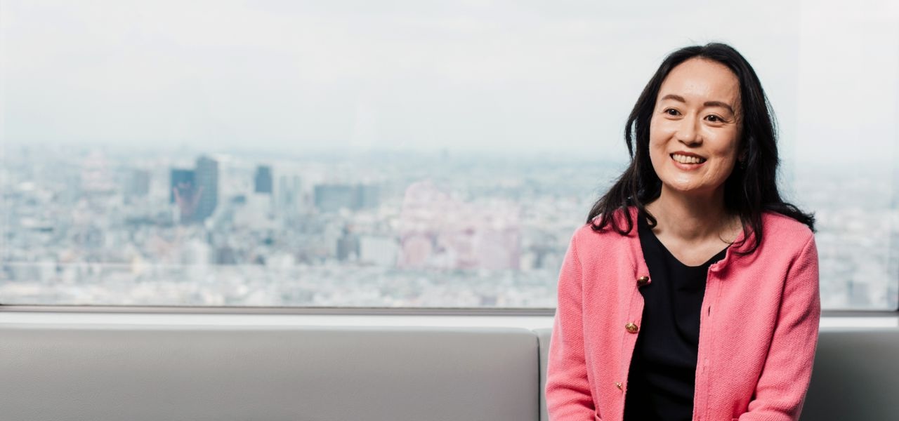 Sanofian working at office sat in front of window showing city landscape