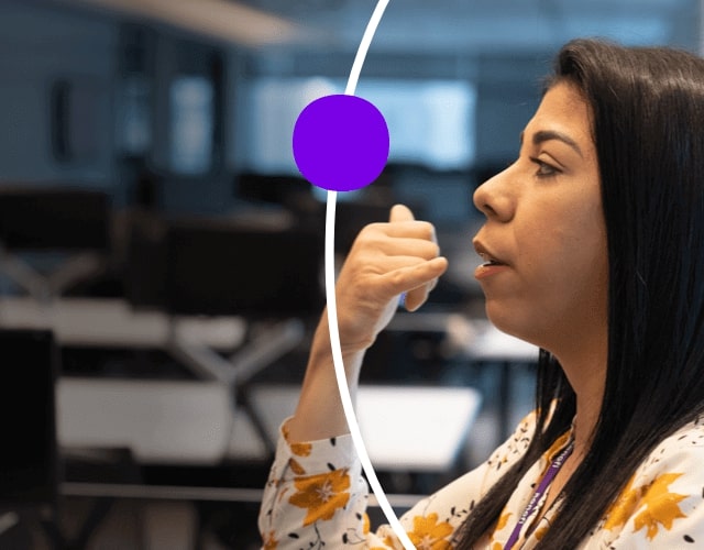 Femme assise à un bureau, parlant en langue des signes