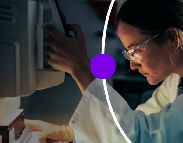 Femme en blouse de laboratoire et lunettes de sécurité utilisant un instrument de laboratoire