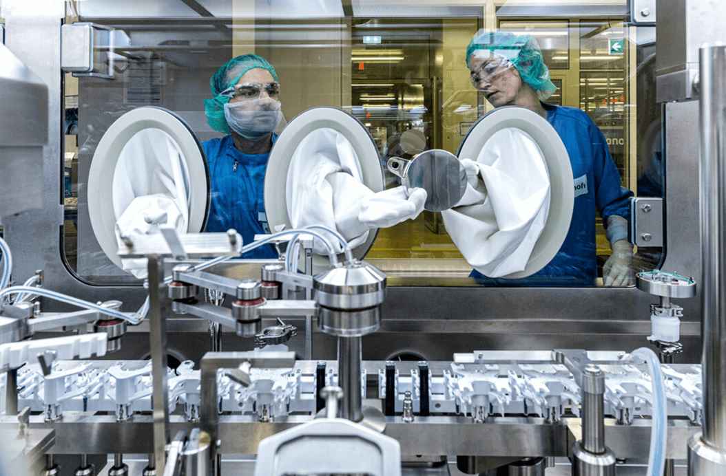 Pharmaceutical workers operating machinery
