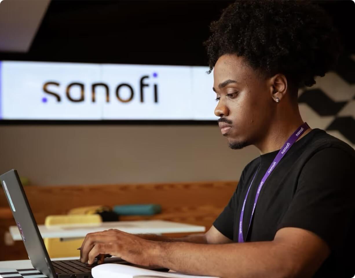 Young Sanofi employee working on a laptop
