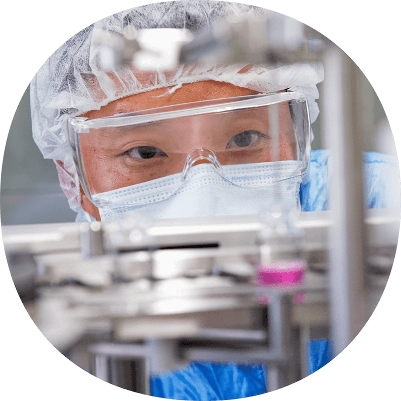 Personne en tenue stérile et masque facial travaillant dans un laboratoire