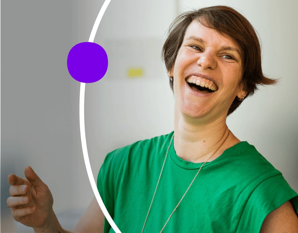 Person in conference room, laughing with other meeting attendees