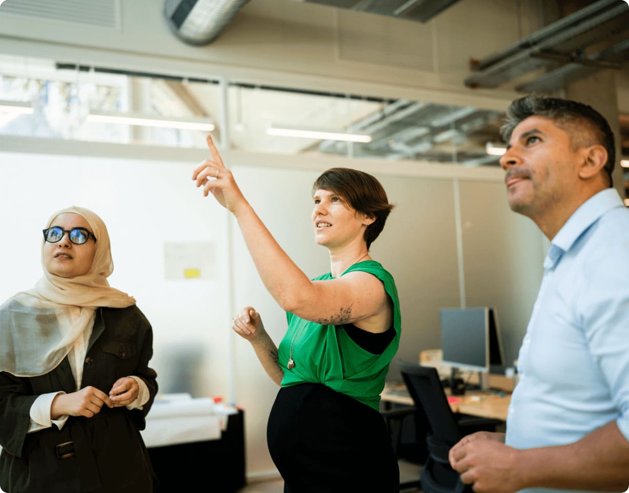 groupe d'employés regardant vers où pointe un employé