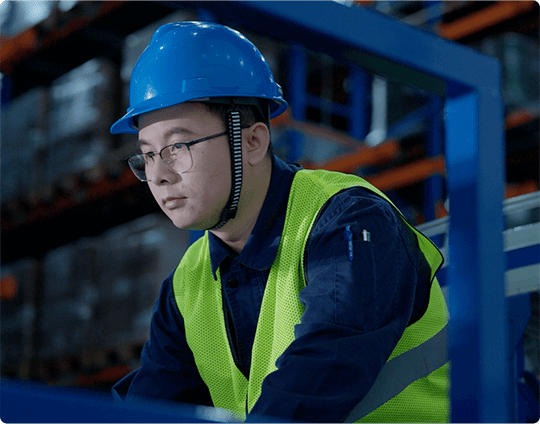 Lab employee in sterile garb looking at lab instrument