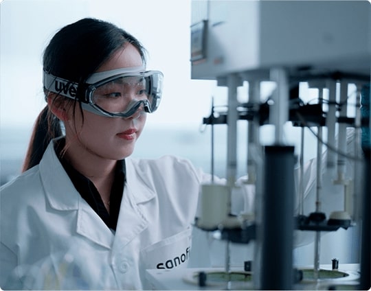 Employé de laboratoire portant des lunettes de sécurité, triant les échantillons de test