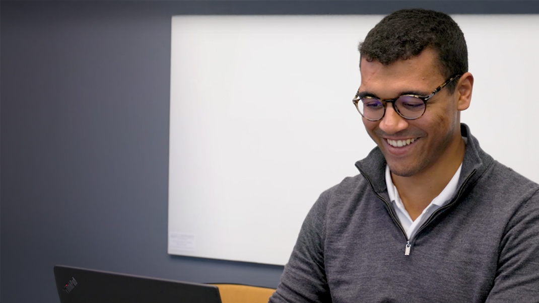 Person working on a laptop in an office setting.